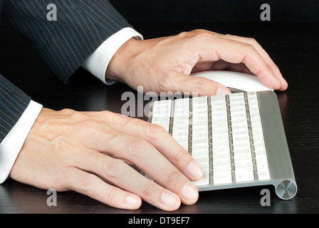 Close-up of a businessman working on a computer keyboard. Stock Photo
