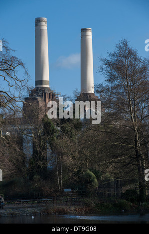 Battersea Power Station chimneys poke through trees in Battersea Park Stock Photo