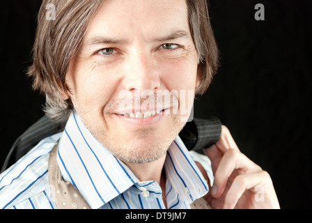 Close-up of a happy businessman holding his jacket over his shoulder. Stock Photo