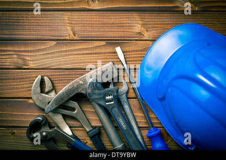 hard hat with various working tools on wooden background Stock Photo