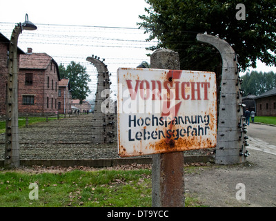 A warning sign for high voltage in the fence at the Nazi Concentration Camp in Auschwitz in Poland Stock Photo
