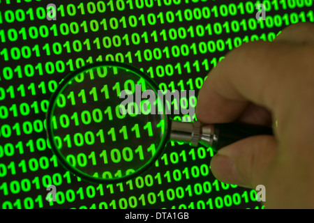 Binary code viewed through a magnifying glass Stock Photo