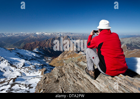 Mountain climber on the summit of Wilde Kreuzspitze Mountain with views over the Pfunderer Mountains towards the Wipptal valley Stock Photo