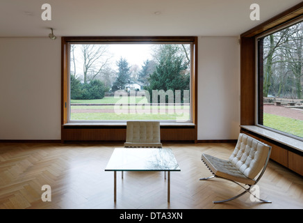 Innenraum (Wohnzimmer mit versenkbaren Fenstern) von Haus Lange mit Blick in den Garten nach Norden Stock Photo