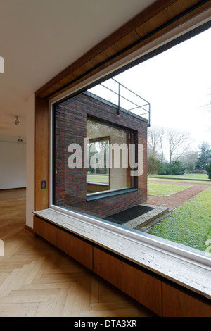 Innenraum (Wohnzimmer mit versenkbaren Fenstern) von Haus Lange mit Blick in den Garten nach Nordwesten Stock Photo