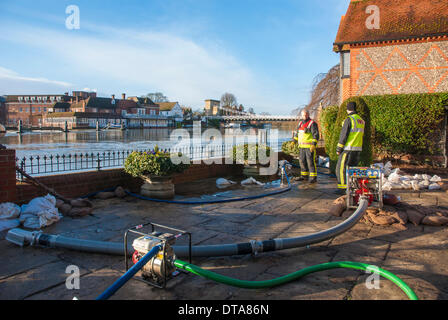 Marlow, UK. 13th Feb, 2014. Nick Chadzynski and Wayne Burry from the Buckinghamshire Fire and Rescue Service pump water from a riverside property in St Peters Street in Marlow as water levels on the River Thames remain extremely high. A severe storm brought winds of more than 100 MPH to some parts of the country. Forecasters are predicting more wet and windy weather to come. Credit:  Peter Manning/Alamy Live News Stock Photo