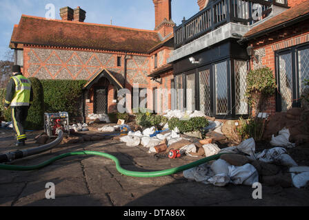 Marlow, UK. 13th Feb, 2014. Wayne Burry from the Buckinghamshire Fire and Rescue Service pumps water from a riverside property in St Peters Street in Marlow as water levels on the River Thames remain extremely high. A severe storm brought winds of more than 100 MPH to some parts of the country. Forecasters are predicting more wet and windy weather to come. Credit:  Peter Manning/Alamy Live News Stock Photo