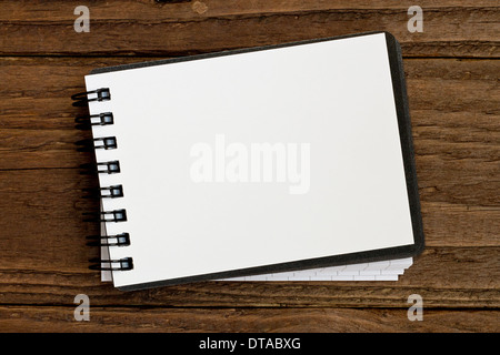 Small blank notepad in landscape orientation against a rustic wooden background Stock Photo