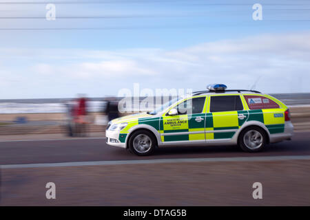 Cars side view road blur; NHS ambulance in Blackpool 13th February, 2014.  A large deployment of Police and emergency rescue services vehicles on the seafront Tower esplanade responding and patrolling promenade as High Tides and Gale Force winds continue to batter the Fylde Coast in Lancashire. Stock Photo