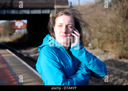 Young Women Telephone On Train Station Platform . Stock Photo