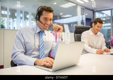 Businessman in office on phone with headset, call conference