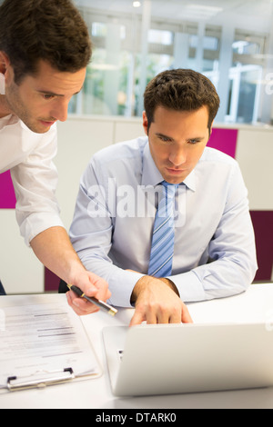 Two handsome businessmen working together on a Laptop in the office Stock Photo
