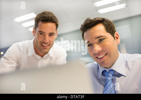 Two handsome businessmen working together on a Laptop in the office Stock Photo
