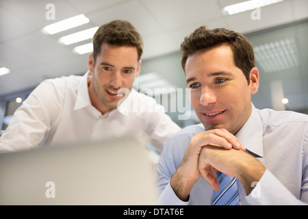 Two handsome businessmen working together on a Laptop in the office Stock Photo
