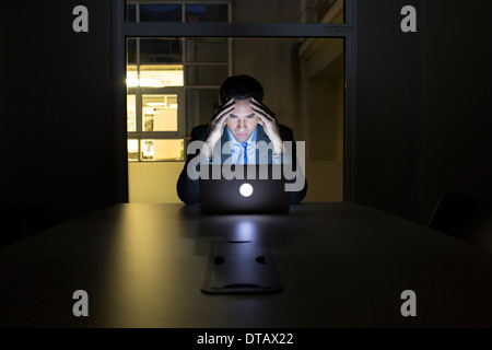 Businessman working late in his office on laptop Stock Photo