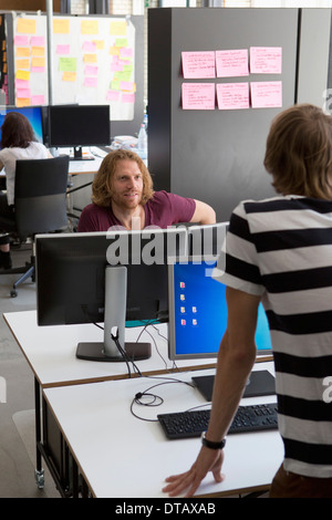 Colleagues talking with each other in office Stock Photo