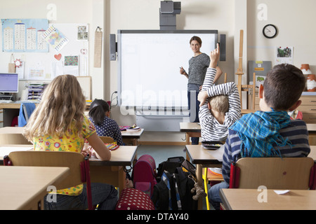 Teacher teaching to students in classroom Stock Photo