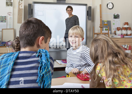 Boy in classroom talking with students Stock Photo