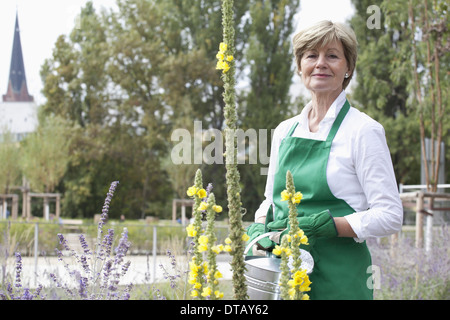 Mature woman holding watering can, portrait Stock Photo