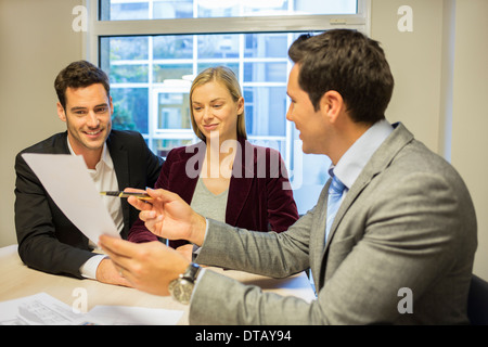 Young couple signing contract in office withe real-estate, new property owners Stock Photo