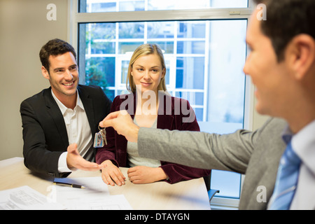 Real-estate agent giving keys to new property owners Stock Photo