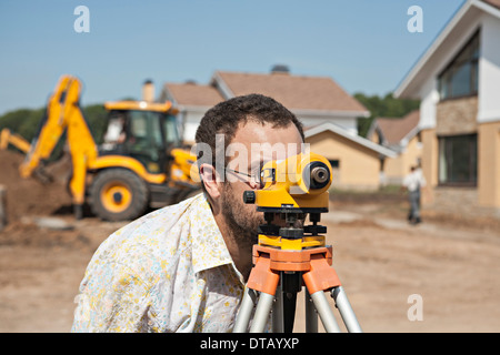 Surveyor using theodolite instrument for measuring levels on construction site Stock Photo