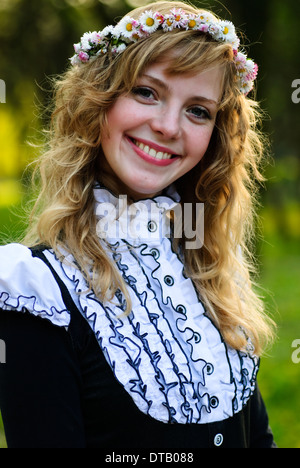 blonde girl in garland from daisies, outdoor portrait Stock Photo