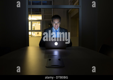 Businessman working late in his office on laptop Stock Photo