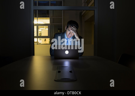 Businessman working late in his office on laptop Stock Photo