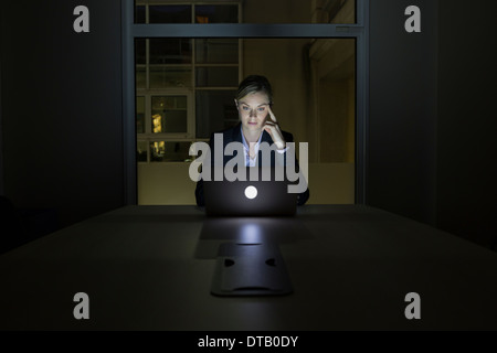 Businesswoman working late in his office on laptop Stock Photo
