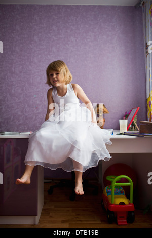 Portrait of girl sitting on table Stock Photo
