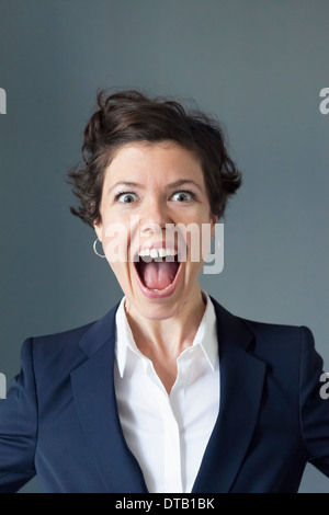Portrait of mid adult woman with open mouth, close-up Stock Photo