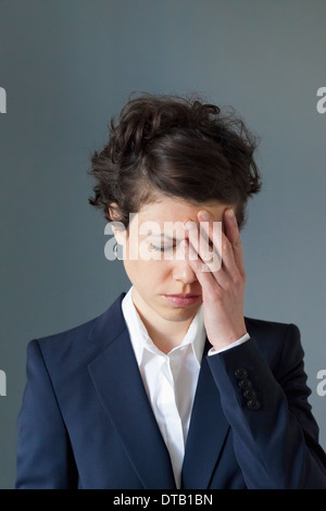 A stressed looking mid adult woman with hand covering face Stock Photo