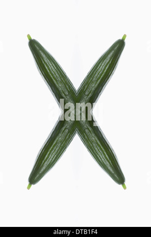 A digital composite of mirrored images of cucumbers in the shape of an X Stock Photo