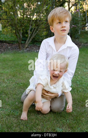 Saarbruecken, Germany, a big brother with his little sister in the garden Stock Photo