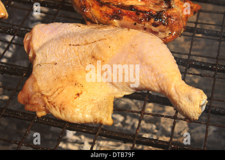 Grilled chicken thigh on the flaming grill Stock Photo