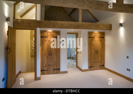 Upmarket attic bedroom conversion with ensuite bathroom and wood beam features. Stock Photo