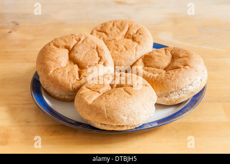 Fresh brown wholemeal bread rolls, baps or cobs on a plate Stock Photo