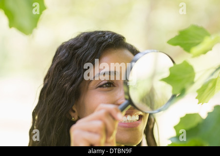 Woman examining leaves with magnifying glass Stock Photo