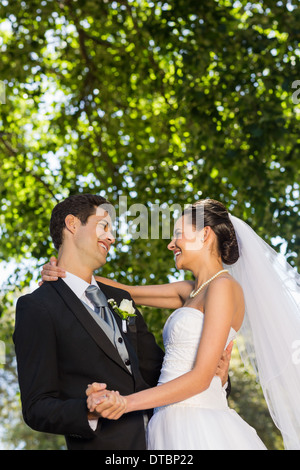 Romantic newlywed couple dancing in park Stock Photo