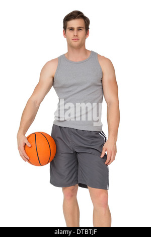 Fit man holding basketball Stock Photo