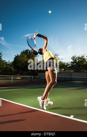 Female tennis player hitting ball Stock Photo