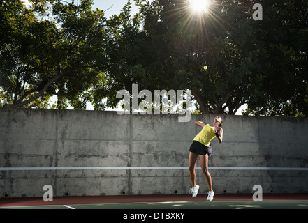 Female tennis player hitting ball Stock Photo