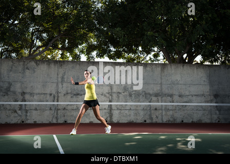 Female tennis player hitting ball Stock Photo