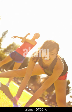 Two young women exercising in park Stock Photo