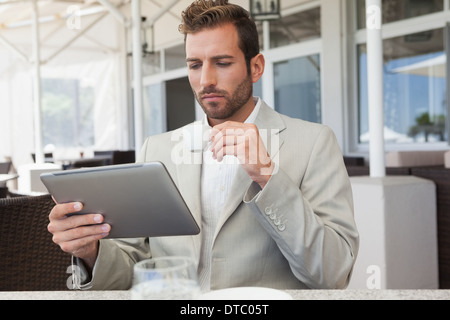 Handsome young businessman working on tablet drinking espresso Stock Photo