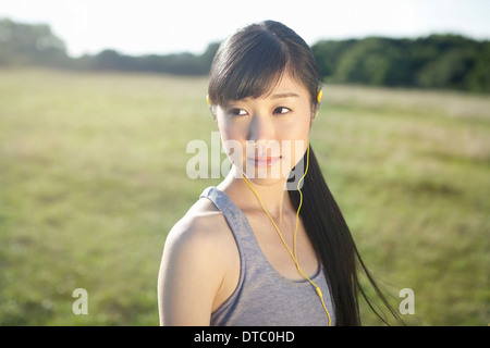 Portrait of young female runner wearing earphones Stock Photo