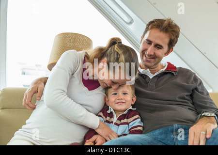 Mid adult couple and toddler son sitting on couch Stock Photo