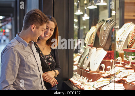 Happy couple looking at jewelry shop window