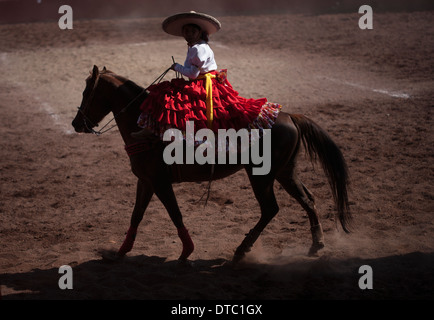 An escaramuza rides her horse before competing in an Escaramuza in the Lienzo Charros el Penon, Mexico City Stock Photo